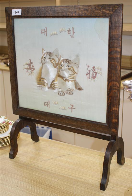 An early 20th century Japanese silkwork panel of two kittens, mounted as an oak firescreen, panel 40 x 43cm